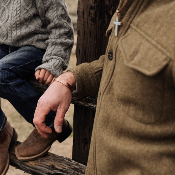 Man wearing turquoise cross necklace