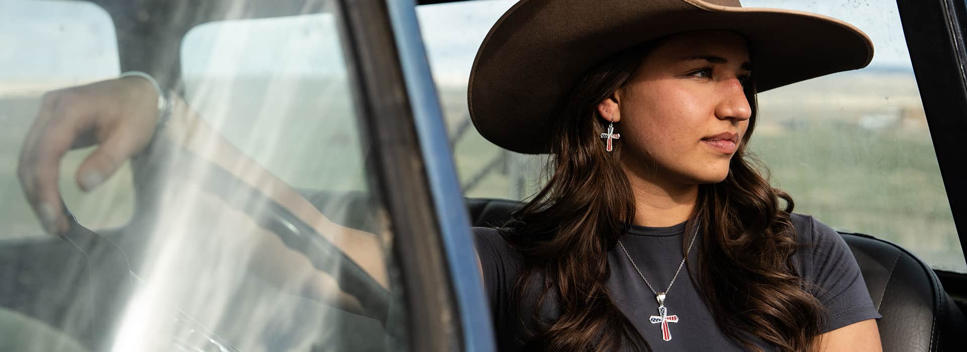 Women in cowboy hat with cross jewelry 