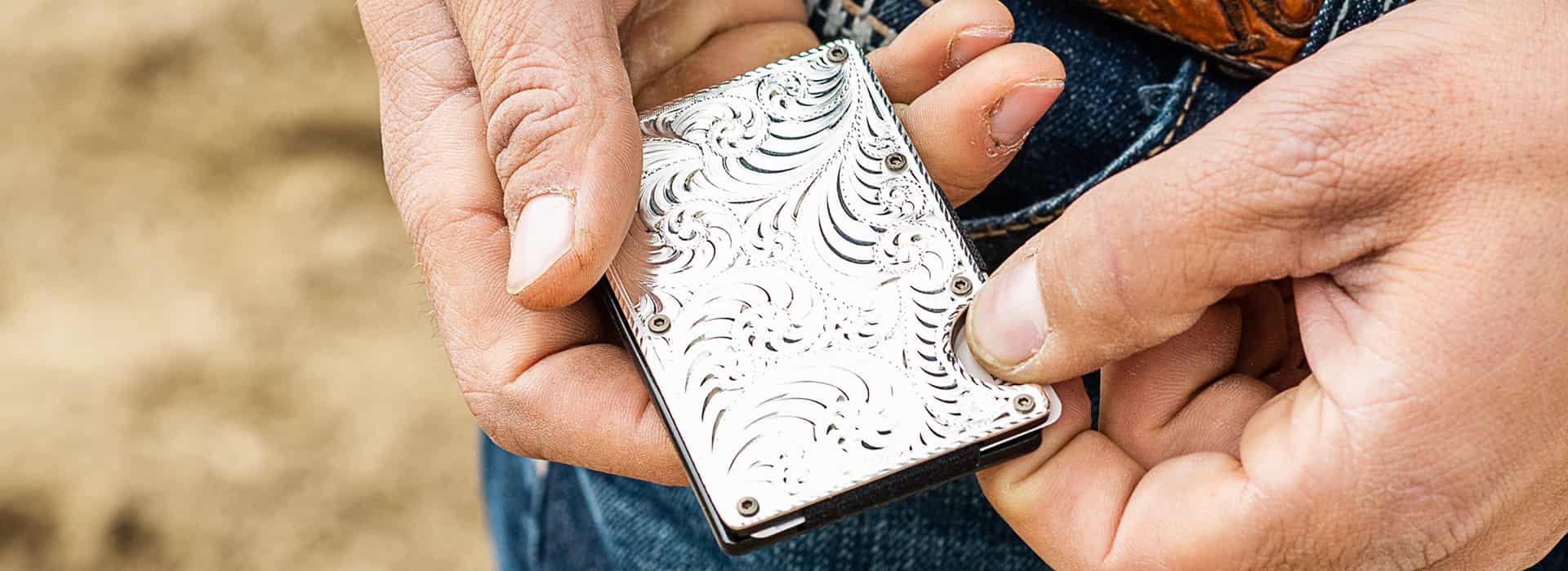 hands holding silver credit card case 