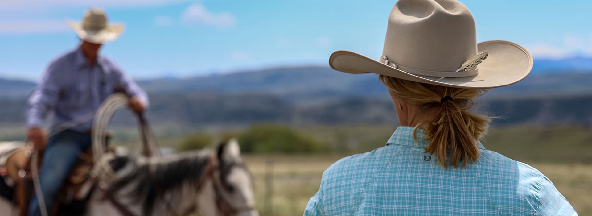 Women wearing cowboy hat with feather hat pick