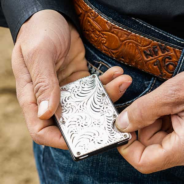 hands holding silver credit card case 